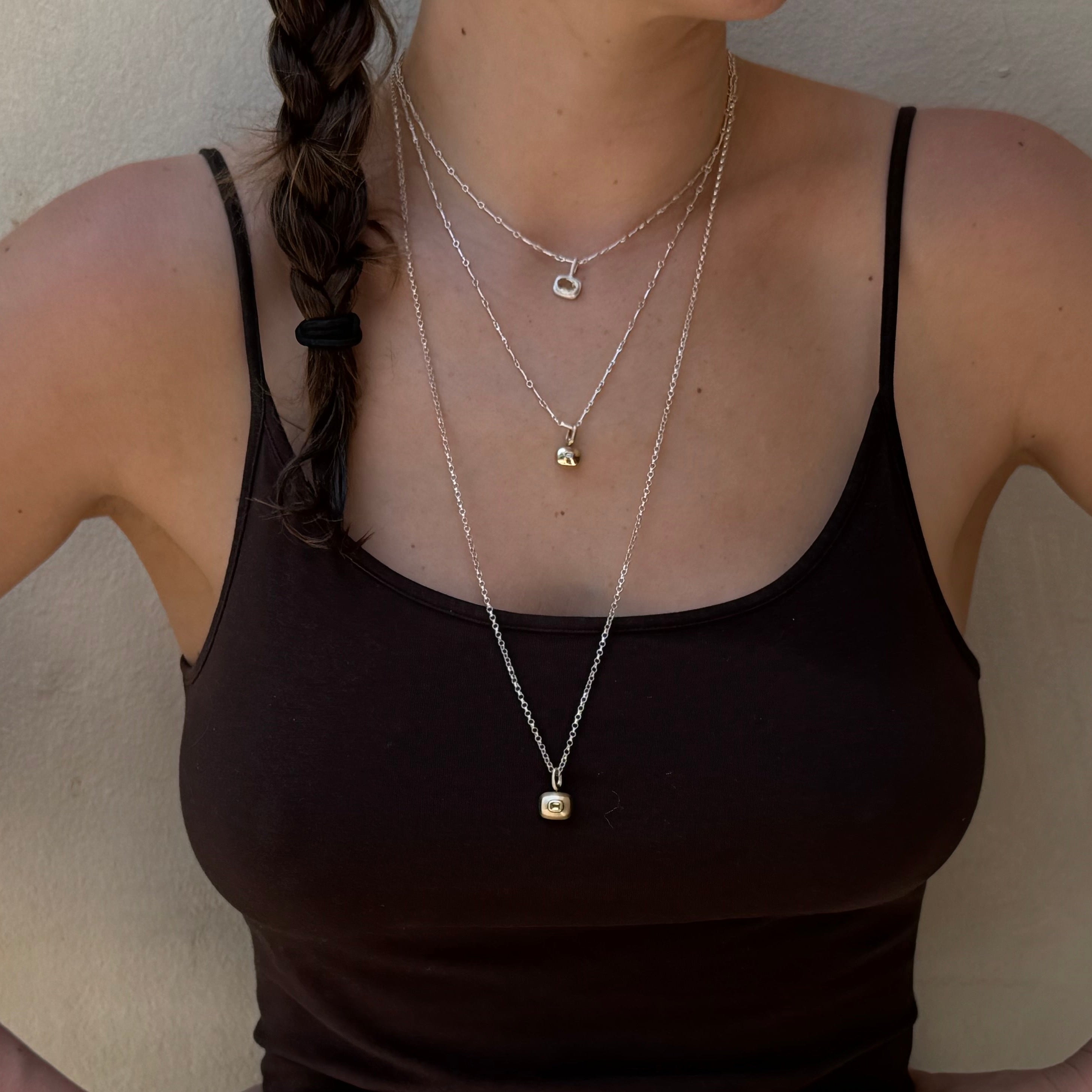 model wearing sterling silver bar chain necklaces and hand made sapphire 10k pendants by em jono